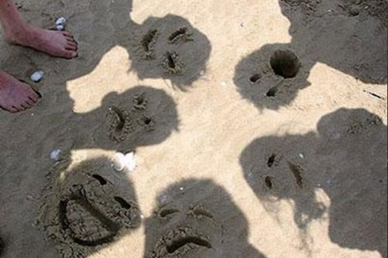 идея для фотосесии: фото тени на песке с дорисованными на песке смайликами