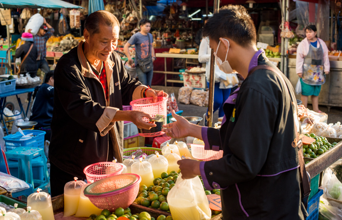 Two Asian men in a market trading