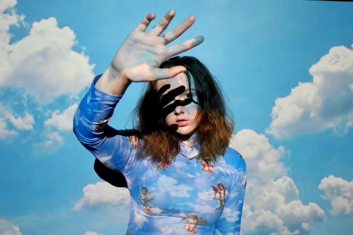A portrait of a female model with a projected photo of clouds on her