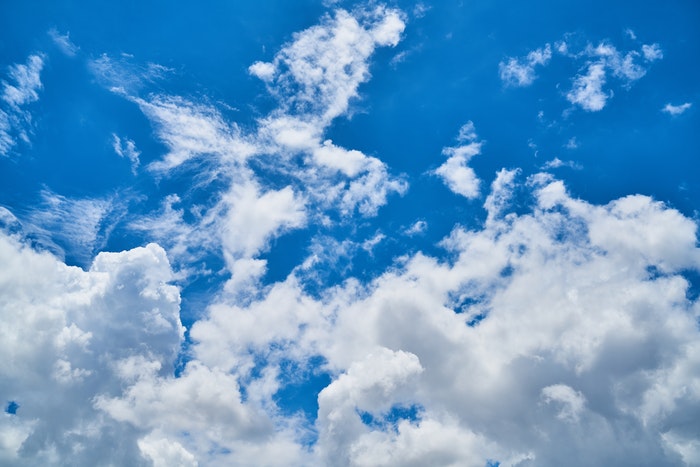 photo of fluffy clouds in the bright blue sky