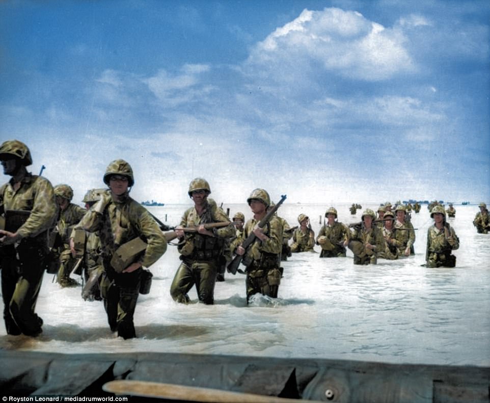 US Marines wading through surf from landing boats and barges to the beach during the invasion of Tarawa. The US laid siege to the Tarawa Atoll between November 20 and November 23, and was America